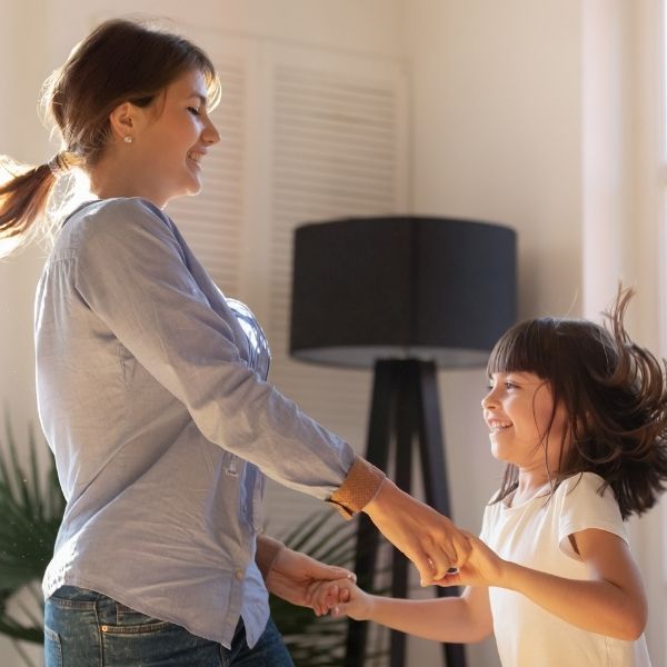 woman and girl dance in living room